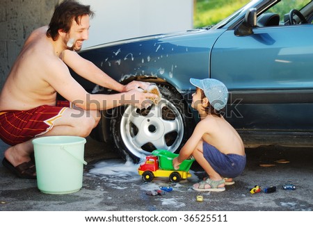 Father and little son are playing and washing car
