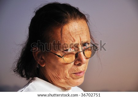 Angry face of elderly woman with nice background