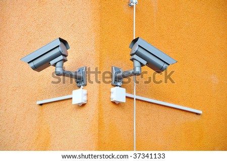 Two security cameras on two sides of building