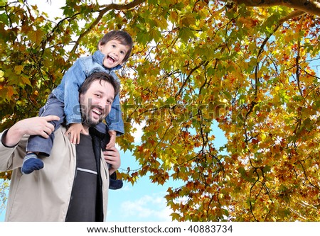 Happy father and his son on the back, fall