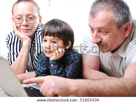 Elderly couple with kid on laptop