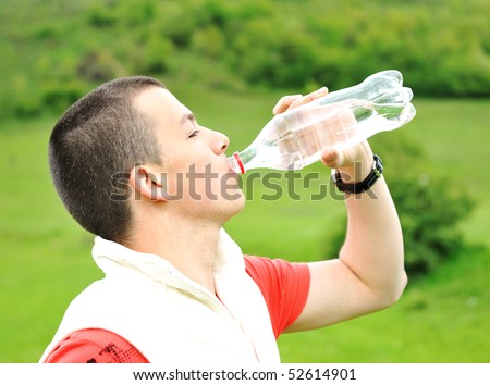 Young man drinking water in nature