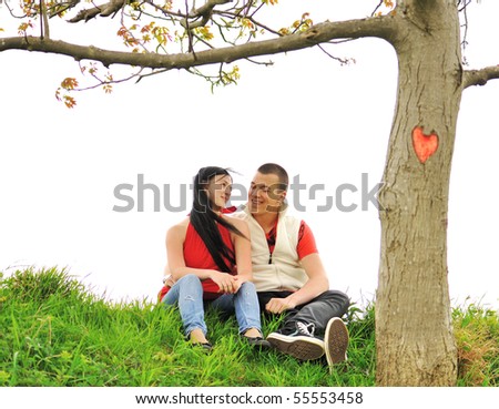 Happy young couple under the tree with a shape of the heart on
