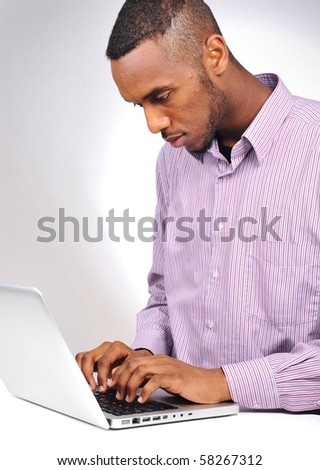 young black man typing  on laptop