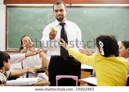 Young male teacher with children in modern school, activities