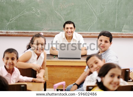 Happy young teacher and children in classroom together