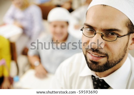 Middle East teacher in school classroom with children in background