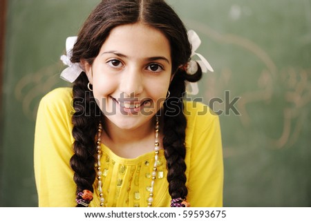 Adorable girl in front of classroom board