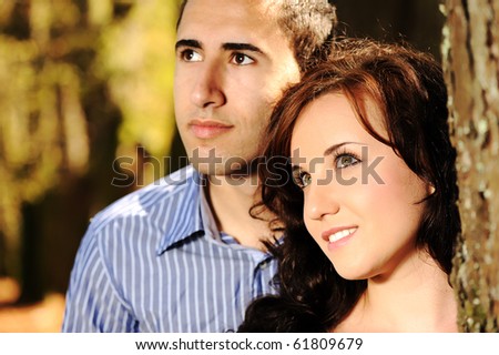 Portrait of love couple embracing outdoor in park looking happy, fall