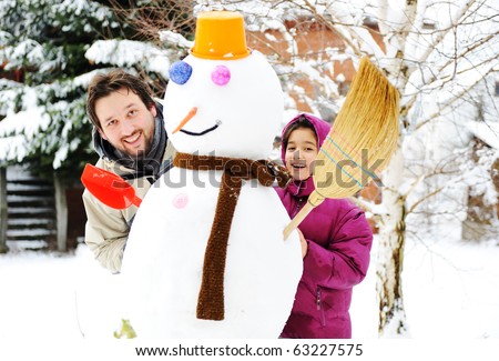 Father and daughter, dad and girl playing game with snow-man, winter, december-january