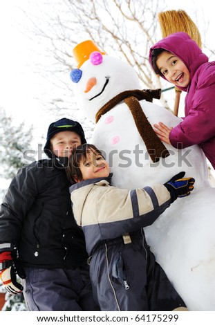 Group of three children playing outdoor with snowman, winter, happiness and playing games