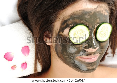 Dead Sea Mud Mask on the woman\'s face. Spa with vegetable and cucumber