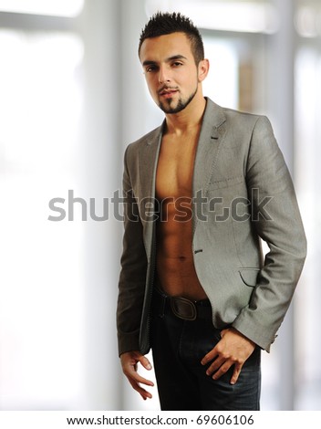 Image of a young stylish fashionable man standing near a window - Indoor