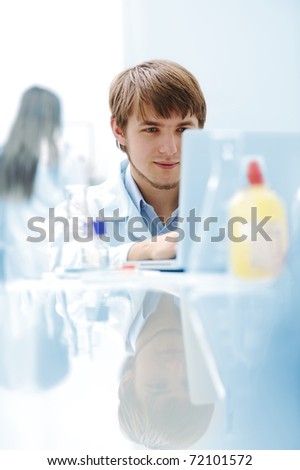 Young medical scientist working in modern lab, research with tubes and notebook