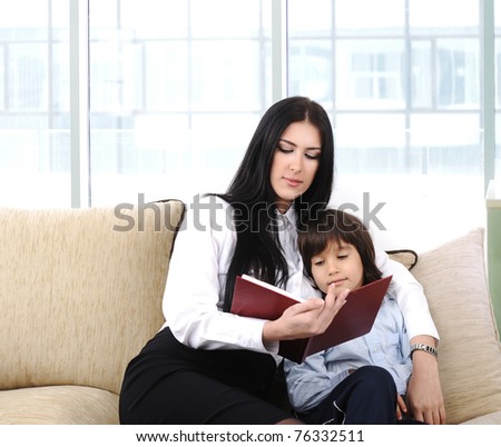 Mother and a son reading a book at home