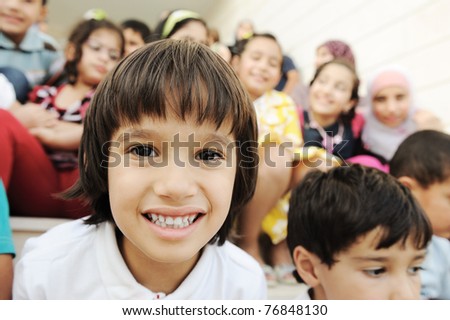 Crowd of children, different ages and races in front of the school, breaktime