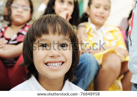 Large group, crowd, lot of happy children of different ages, summer outdoor sitting