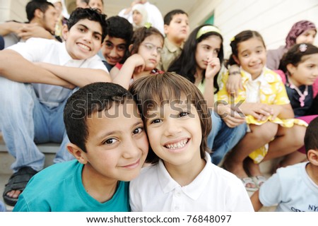 Crowd of children, different ages and races in front of the school, breaktime