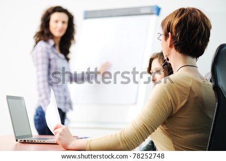 Business women holding a conference writing on an a board in an office
