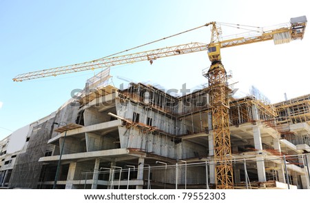 Buildings under construction and cranes under a blue sky