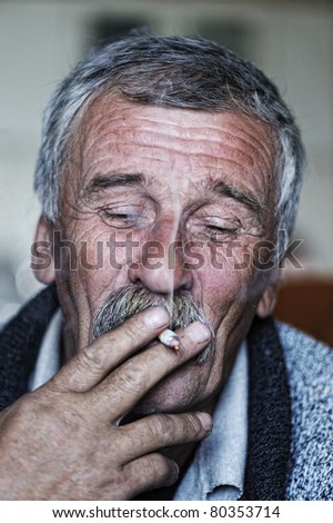 Common elderly man with mustache smoking cigarette