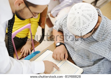 Education activities in classroom at school, Muslim teacher showing Koran to kid