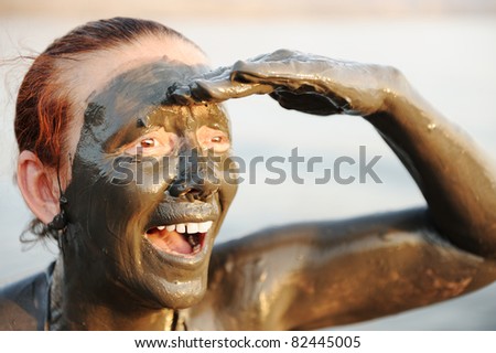 Elderly woman in a bathing suit of natural mineral mud sourced from the dead sea in Jordan