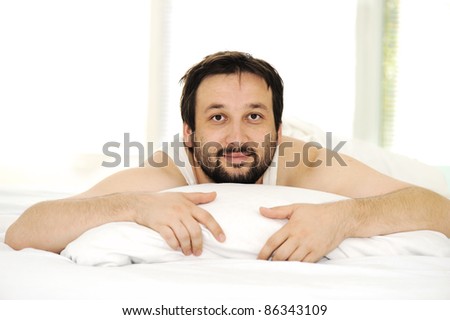 Man in sleeping bed, morning time