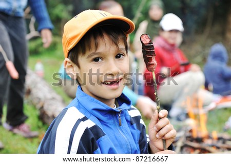 Barbecue in nature, group of children  preparing sausages on fire