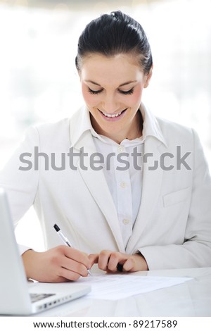 Happy business woman signing documents at office