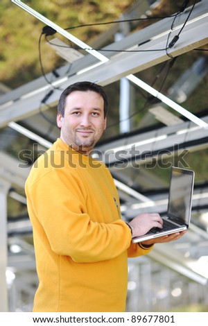 Engineer using laptop and connecting wires at work place