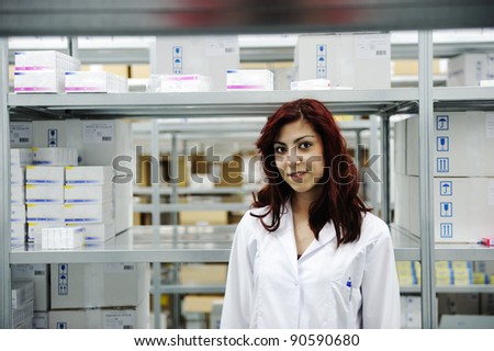 Young cheerful female worker in modern warehouse