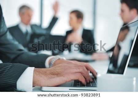 Business ambiance, typing report on laptop during the meeting