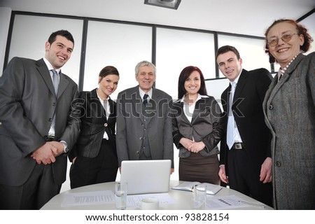 Multi aged business people standing around the table at office