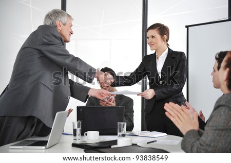 Business partners handshaking at meeting and receiving applause