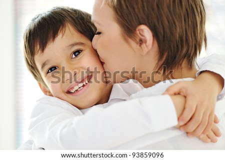 Happy mother embracing and kissing her son