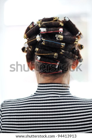 Woman with curlers on head, back