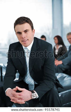 Businessman with his co-workers in office smiling, looking at camera