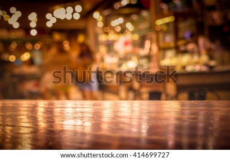 Real wood table with light reflection on scene at restaurant, pub or bar at night. Blurred background for product display or montage your products with several concept idea and any occasional.