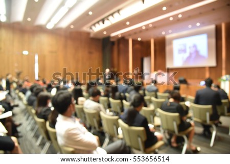 Blurred image of education people and business people sitting in conference room for profession seminar and the speaker is presenting new technology and idea sharing with the content activity.