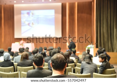Blurred image of education people and business people sitting in conference room for profession seminar and the speaker is presenting new technology and idea sharing with the content activity.