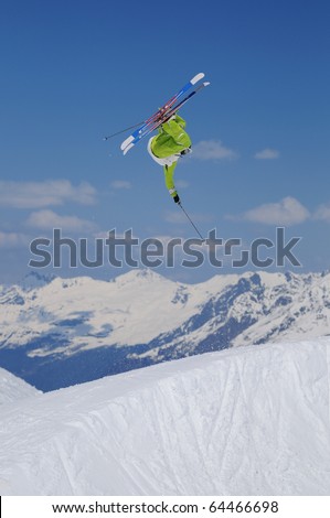 Jumping freestyle skier in the air. Extreme sports athlete jumping in the mountains.