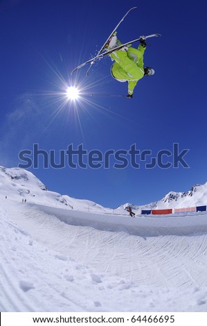 Jumping freestyle skier in the air. Extreme sports athlete jumping in the mountains.