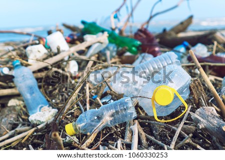 Spilled garbage on the beach of the big city. Empty used dirty plastic bottles. Dirty sea sandy shore of the Black Sea. Environmental pollution. Ecological problem