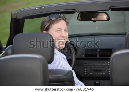 Young woman driving a sports cabriolet car