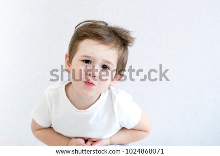 Caucasian little boy with stomach ache, child holding his hands on his belly. Stomach ache child stock image.