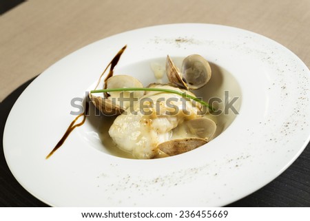 white plate with fish and clams