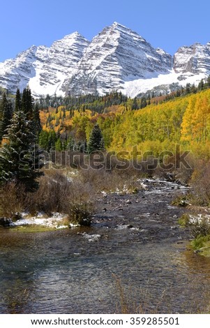 Maroon Bells and Creek in Autumn - Vertical - An autumn morning after a light overnight snowfall,  Maroon Creek, filled with crystal clear stream, running down from Maroon Bells, Aspen, Colorado, USA.