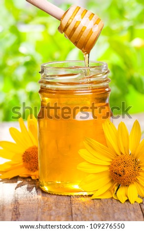 pouring honey from drizzler into jar