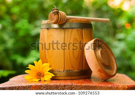 wooden barrel of honey with drizzler and bees